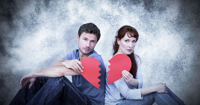 Couple holding a broken heart against grey background