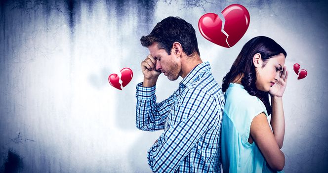 Depressed couple standing back to back against heart