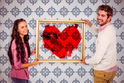 Smiling couple holding picture frame against blue background