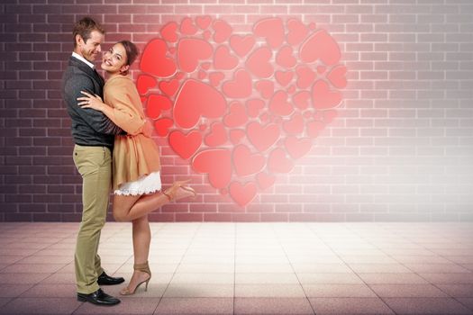 Full length of romantic couple hugging against room with brick wall
