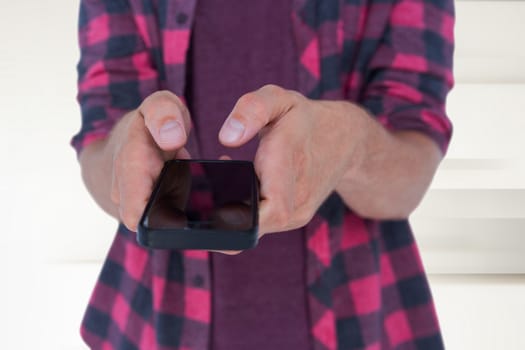 Midsection of man in casuals using smart phone against abstract white design