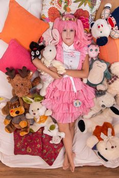 young girl in a bedroom in a pink cute dress