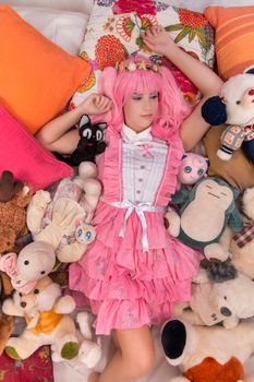 young girl in a bedroom in a pink cute dress