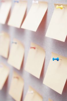 Sticky notes on a bulletin board. Close-up view