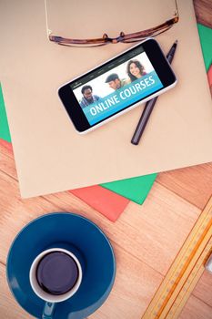 Online courses interface against smartphone and eye glasses on paper by coffee cup at table 