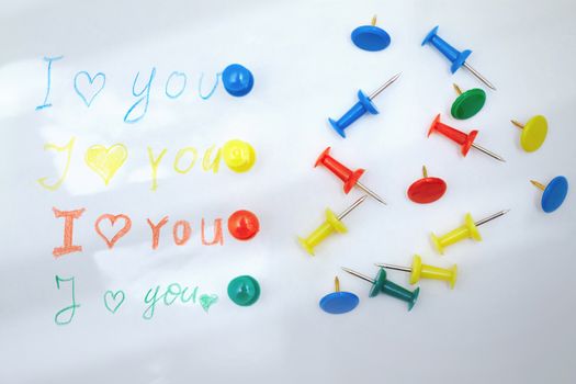 Love you letter with colorful push pins. Sunlight shadows and flare