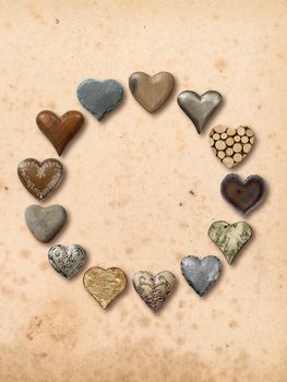 Photos of heart-shaped things made of stone, metal and wood, assembled into a circle over vintage paper background.