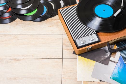 Gramophone with a vinyl records on wooden table, top view and copy space.