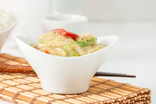 Bowl of green curry chicken photographed closeup.