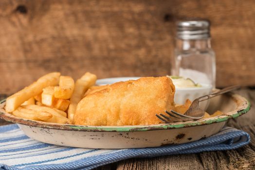 Rustic plate of traditional fish and chips.