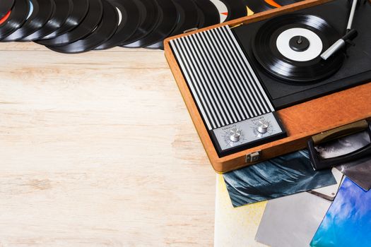 Gramophone with a vinyl records on wooden table, top view and copy space.