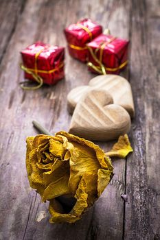 hand-carved symbolic wooden heart on a background of yellow roses