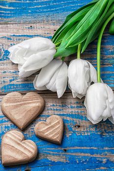 symbolic wooden heart on the background of bouquet of white roses