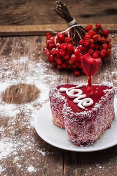 cake in the shape of heart with the inscription love and bunch of berries of viburnum