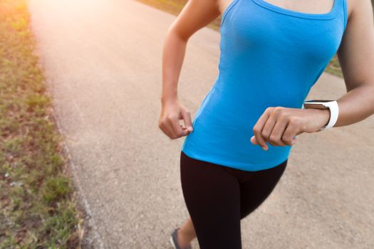 closeup woman running on rural road during sunset