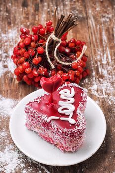 cake in the shape of heart with the inscription love and bunch of berries of viburnum