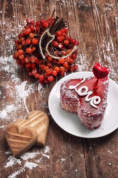 cake in the shape of heart with the inscription love and bunch of berries of viburnum