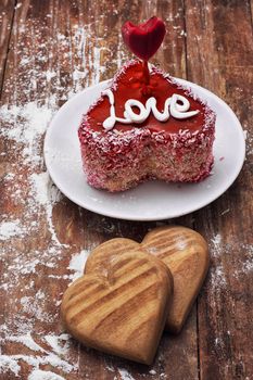 cake in the shape of heart with the inscription love and bunch of berries of viburnum