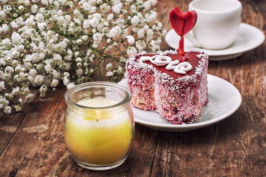 cake in the shape of heart with the inscription love and bunch of berries of viburnum