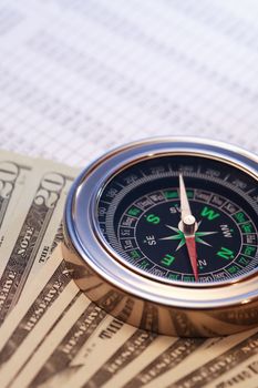 Business concept. Closeup of compass and money on paper list with digits