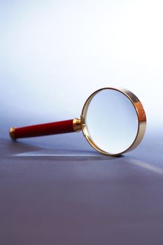 Magnifying glass under beam of light on dark background