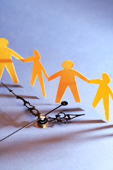 Yellow paper men against clock on dark background