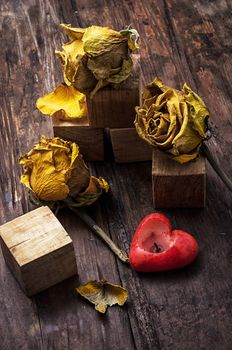 hand-carved symbolic wooden cubes on background of yellow roses