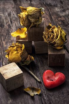 hand-carved symbolic wooden cubes on background of yellow roses