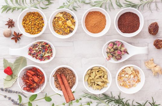 An arrangement of spices and herbs on rustic background. Top view, blank space, vintage toned image. Natural light