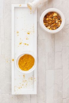Home-made curry powder being crushed in a mortar. Top view, blank space, vintage toned image. Natural light