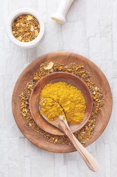 Curry spices in a shallow bowl with a spoon. Top view, blank space, vintage toned image. Natural light