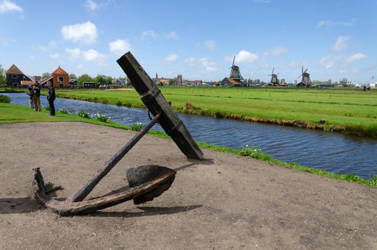 Zaanse Schans, Netherlands - May 5, 2015: Tourists visit Windmills and rural houses in Zaanse Schans, Netherlands. This village is a popular touristic destination in Netherlands