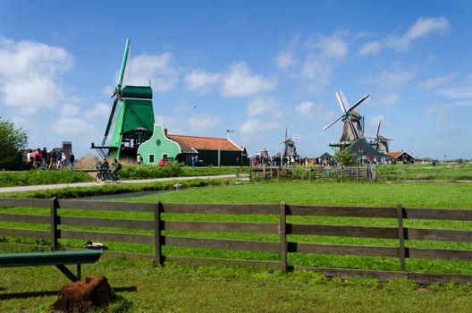 Zaanse Schans, Netherlands - May 5, 2015: Tourists visit Windmills and rural houses in Zaanse Schans, Netherlands. This village is a popular touristic destination in Netherlands