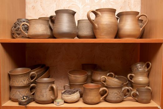 Many handmade old clay pots on the shelf.