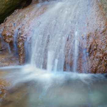 Waterfall in the forest. Image of motion water flow