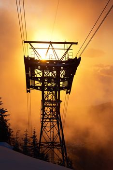 Sunset in the winter forest. Silhouette of the cable rail. Vancouver, Seymour mountain