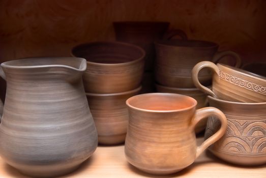 Many handmade old clay pots on the shelf.