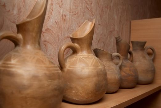 Many handmade old clay pots on the shelf.