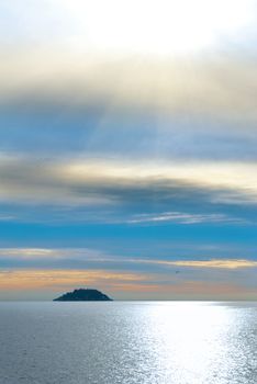 Small island in the sea. Sunset above the ocean