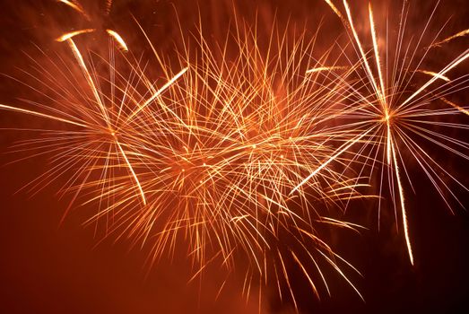 Red colorful fireworks on the black sky background. Holiday celebration.