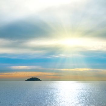 Small island in the sea. Sunset above the ocean