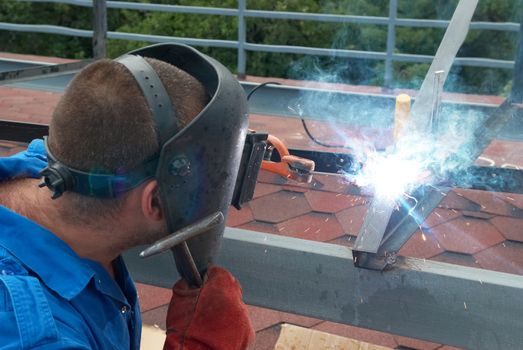 Welder at the factory working with metal construction