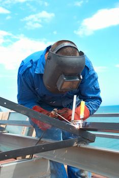 Welder at the factory working with metal construction