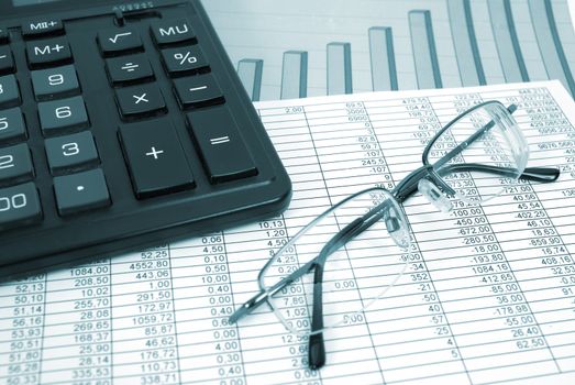 Glasses and calculator on paper table with finance diagram