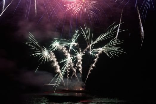 Colorful holiday fireworks on the black sky background.