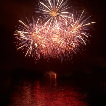 Red colorful holiday fireworks on the black sky background.