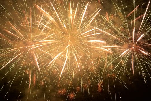 Red amd yellow colorful holiday fireworks on the black sky background.