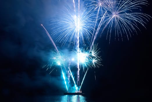 Blue colorful holiday fireworks on the black sky background.