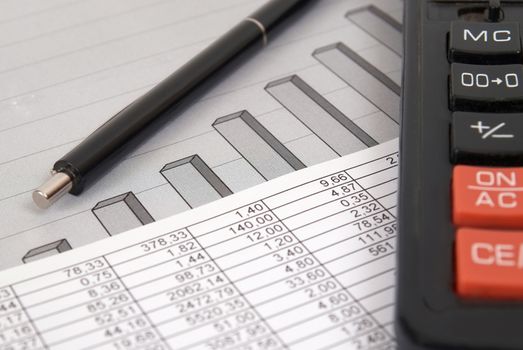 Pen and calculator on paper table with finance diagram