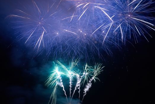 Blue colorful holiday fireworks on the black sky background.